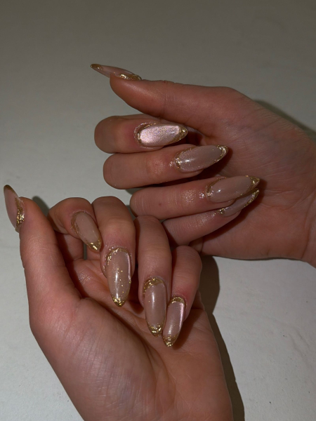 A close up of Tate McRae's gold and cateye polish nails from the 2026 Met Gala.